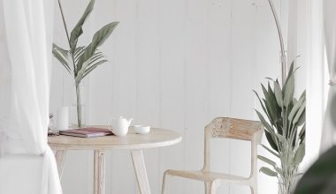 white steel chair in front round table on white rug