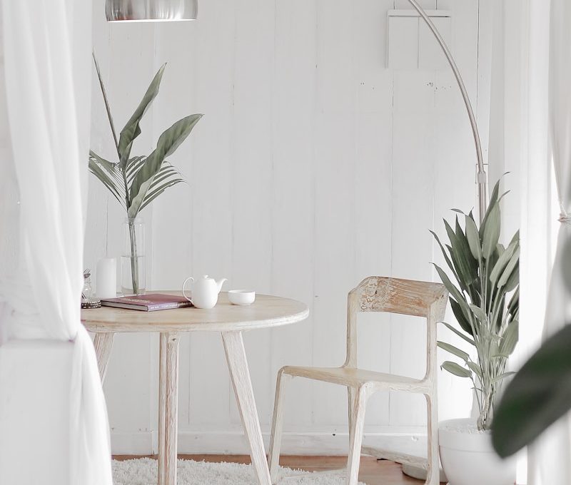 white steel chair in front round table on white rug