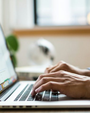 person typing on silver MacBook