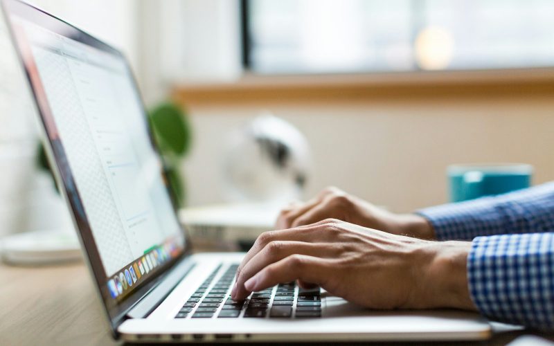 person typing on silver MacBook