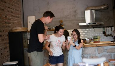 woman wearing white crew-neck shirt looking at smartphone friends