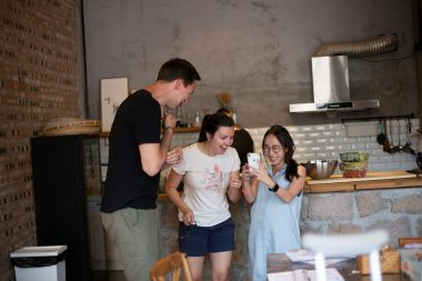 woman wearing white crew-neck shirt looking at smartphone friends