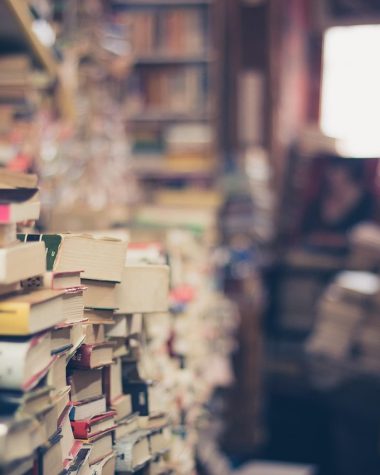 Rommelige woonkamer met stapels boeken en spullen op de vloer