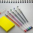 Persoon schrijft een takenschema op papier aan een bureau